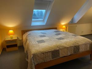 ein Schlafzimmer mit einem Bett mit zwei Nachttischen und zwei Lampen in der Unterkunft Cafe Gaubenhaus in Bad Fallingbostel
