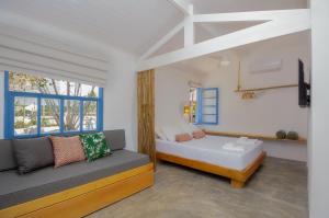um quarto com uma cama, um sofá e uma janela em Villa Tennis em Ubatuba