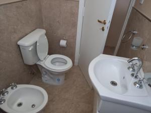 a bathroom with a white toilet and a sink at Departamento Necochea in Necochea