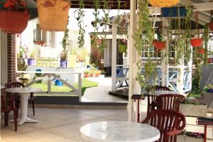 un restaurante con mesas y sillas y un patio en Hostería Anchimalen en Villa Gesell