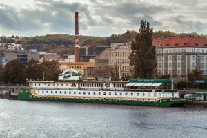una grande barca verde e bianca sull'acqua di Admiral Botel a Praga