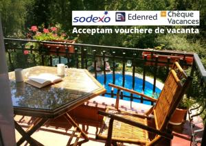 a table and chairs on a balcony with a pool at Club Topaz Apartments in Neptun