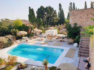 una piscina en un patio con sillas y sombrillas en Las Fincas de Annie, en Felanitx