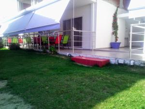 a patio with tables and chairs under a tent at Persefoni Rooms Apartments & Mezonetes in Toroni