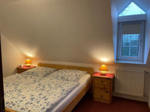 ein Schlafzimmer mit einem Bett und zwei Lampen an Nachttischen in der Unterkunft Cafe Gaubenhaus in Bad Fallingbostel