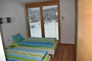 Habitación pequeña con 2 camas y ventana en Curvér 3002 Ir Apart Irene, en Lenz
