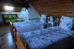 Duas camas num quarto com paredes de madeira em Chambres d'hôtes Les Magnolias em Saint-Chéron