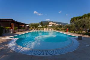 a large swimming pool with blue water in a resort at Agriturismo La Panoramica in Assisi