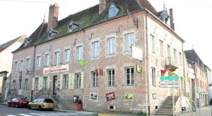 un gran edificio de ladrillo en la esquina de una calle en Logis Hostellerie Bressane, en Saint-Germain-du-Bois