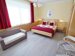 ein Hotelzimmer mit einem Bett und einer Couch in der Unterkunft Pension Kathi in Sankt Kanzian am Klopeiner See