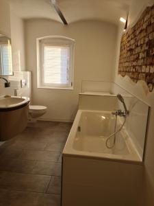 a bathroom with a tub and a toilet and a sink at Ferienwohnung in Bernau bei Berlin