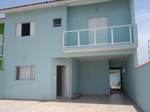 a blue building with a balcony on top of it at Casa com piscina à beira-mar in Itanhaém