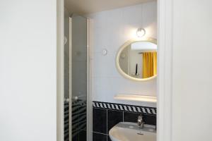uma casa de banho com um lavatório e um espelho em Chambres d'hôtes Les Magnolias em Saint-Chéron