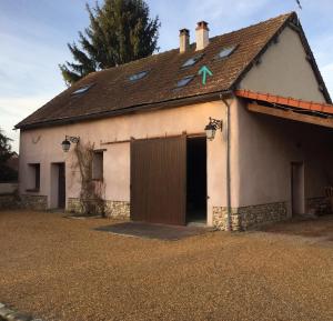 a small white building with a large garage at Hôte à Chaudon in Chaudon