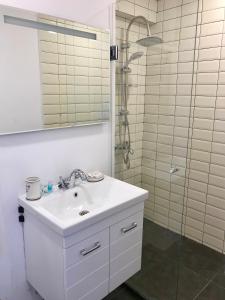 a white bathroom with a sink and a shower at GVC 2-level apt New Gudauri in Gudauri