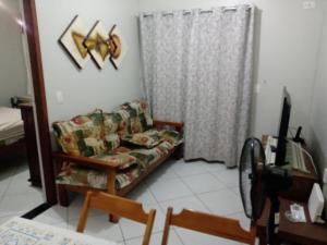 uma sala de estar com um sofá e uma janela em Apartamento Pé na Areia em São Bernardo do Campo