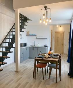 a kitchen and dining room with a table and a staircase at GVC 2-level apt New Gudauri in Gudauri
