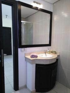 a bathroom with a sink and a large mirror at Bahia Golf Beach in Bouznika