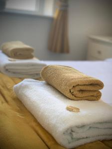 a pile of towels sitting on top of a bed at Seacrest Guest House in Weymouth