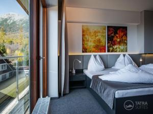 a hotel room with a bed and a balcony at TATRA SUITES Luxury Studio A304 in Vysoke Tatry - Stary Smokovec