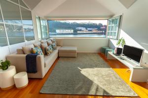 - un salon avec un canapé et une télévision dans l'établissement Duplex Douro River, à Porto
