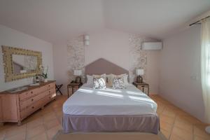 1 dormitorio con 1 cama blanca grande y vestidor en Hotel Borgo Smeraldo en Arzachena
