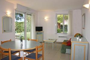 a living room with a table and a couch at Azureva Fouras in Fouras