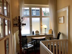 ワイマールにあるPension Villa Giselaのテーブルと椅子、窓が備わる客室です。