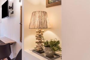 a table with a lamp and a plant on it at Wellness Lodge Diletta in Santa Giuliana