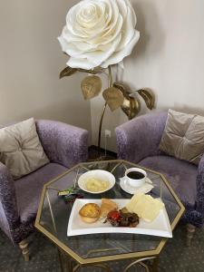 a table with a plate of food and a white rose at Hotel Kaganat in Kazan