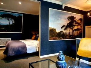 KlimmenにあるBoutique Hotel Villa de Proosdijのベッドルーム1室(ベッド1台付)が備わります。壁には絵画が飾られています。