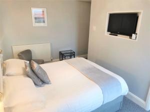 a bedroom with a bed and a flat screen tv at Anglesey House in Llandudno