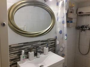 y baño con lavabo, espejo y ducha. en Aegialis, en Skala Kallirakhis