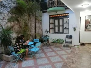 a woman sitting at a table in a room at Casa Mamá Waldy Hostel in Cartagena de Indias