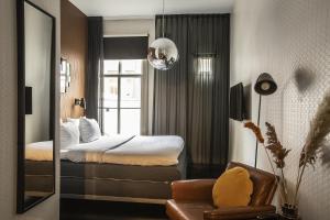 - une chambre d'hôtel avec un lit et un miroir dans l'établissement Hotel V Frederiksplein, à Amsterdam