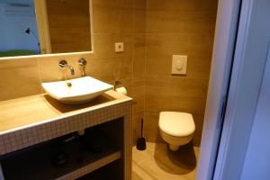 a bathroom with a white sink and a toilet at le petit domaine 07 in Les Vans