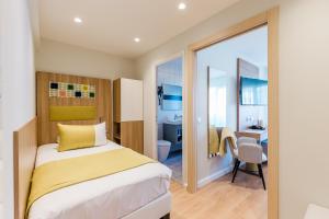 a bedroom with a bed and a bathroom with a desk at Hôtel Hélios in Juan-les-Pins