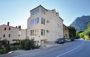 een wit gebouw aan de kant van een straat bij Apartment Mate in Omiš +16 foto's