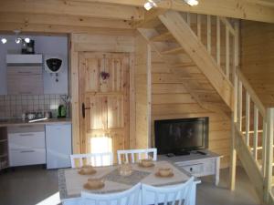 eine Küche mit einem Tisch und einem TV in einem Zimmer in der Unterkunft Domek Stokrotka in Krynica-Zdrój