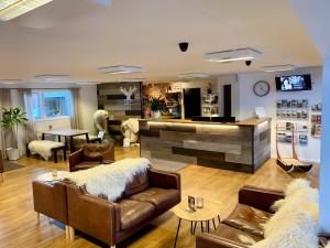 a living room with two leather couches and a kitchen at Backcountry Hotel Sisimiut in Sisimiut