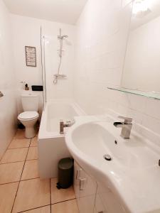 La salle de bains est pourvue d'un lavabo, d'une baignoire et de toilettes. dans l'établissement Station Apartment, à Bellshill