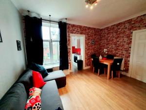 a living room with a couch and a table at Station Apartment in Bellshill