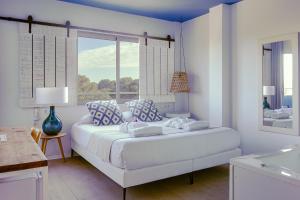 a white bedroom with a large bed and a window at YOU & CO. Saler Beach Boutique in Valencia