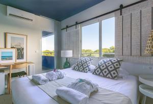 a bedroom with a white bed with towels on it at YOU & CO. Saler Beach Boutique in Valencia