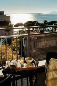 a table with food and drinks on top of a balcony at Hôtel Hélios in Juan-les-Pins