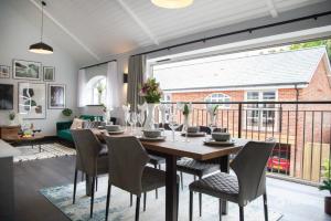 a dining room with a table and chairs and a large window at Ultra luxurious 2 bed apt on stilts, Free Parking - The Gatehouse in Poole