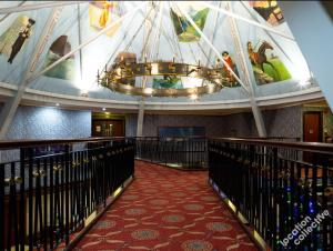 a hallway with a large chandelier in a building at Lakeside International Hotel in Camberley