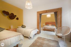 een slaapkamer met 2 bedden en een spiegel bij Villa Caroline - Chambres d'Hôtes in Albi