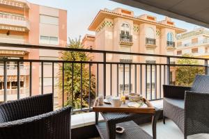 a balcony with a table and chairs and a building at Hôtel Hélios in Juan-les-Pins
