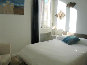 een slaapkamer met een wit bed en een raam bij "AuSoleil" 2 pieces cosy ensoleillé, tout à pied, 50 m du vieux port in Saint-Raphaël